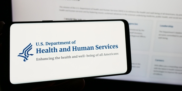 HHS logo on phone screen by laptop